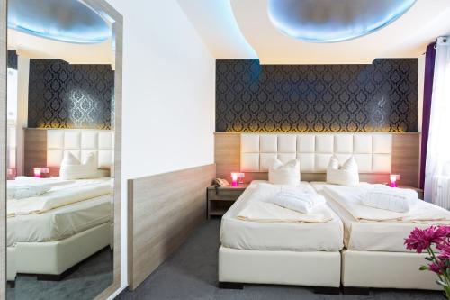 A bed or beds in a room at Bavaria Hotel Münchner Hof Superior