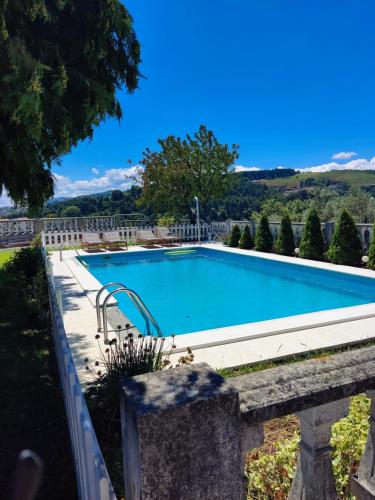 a swimming pool in a yard with a stone wall at Casa da Real Companhia in Lamego