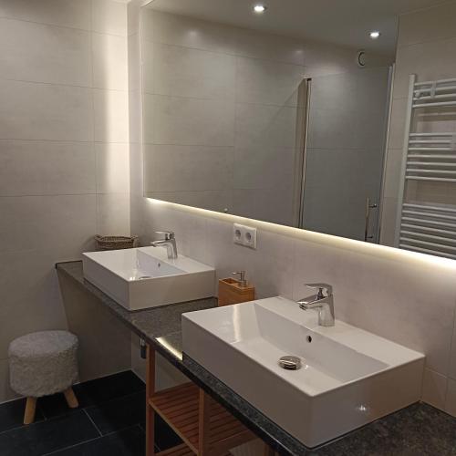 a bathroom with two sinks and a large mirror at Haus Schmid in Tobadill