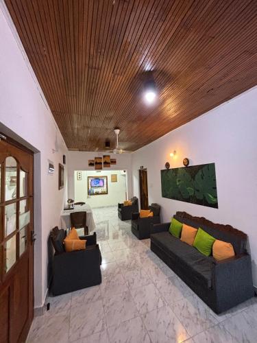 ein Wohnzimmer mit Sofas und einer Holzdecke in der Unterkunft Goalma Family Holiday Resort & Restaurant in Anuradhapura