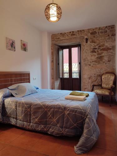a bedroom with a large bed in a stone wall at Casa Floriña in Outes