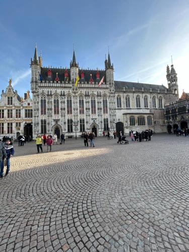 a large building with people walking in front of it at De Bijenkorf in Damme