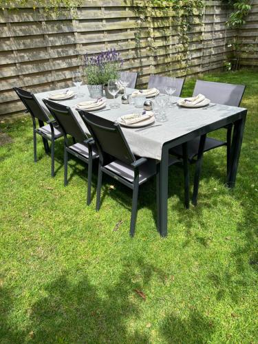 a black table with chairs and plates and wine glasses at De Bijenkorf in Damme