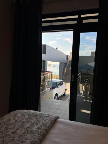 a bedroom with a bed and a view of a parking lot at Low Tide in Densainagar
