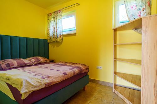 a bedroom with a bed and a book shelf at Całoroczne Domki w Bieszczadach "The Willows" in Łączki