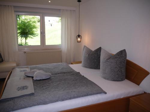 a bedroom with a bed with pillows and a window at Haus Schmid in Tobadill