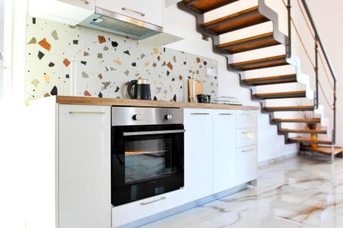 a kitchen with a stove and a staircase at LOUTRA VILLAS in Agia Paraskevi