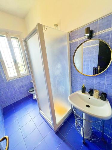 a blue tiled bathroom with a shower and a sink at AMA Esclusive SPA Amore in Ferrara