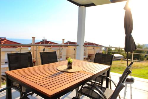 a wooden table and chairs on a patio at LOUTRA VILLAS in Agia Paraskevi