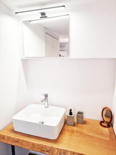 a bathroom with a white sink and a mirror at LOUTRA VILLAS in Agia Paraskevi