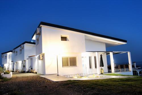 a white house with the ocean in the background at LOUTRA VILLAS in Agia Paraskevi