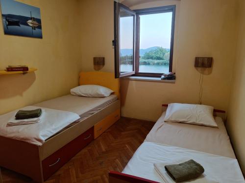 two beds in a room with a window at Nonna Kate in Komin