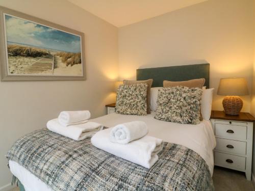 ein Schlafzimmer mit einem Bett mit Handtüchern darauf in der Unterkunft Martin Cottage in Berrynarbor