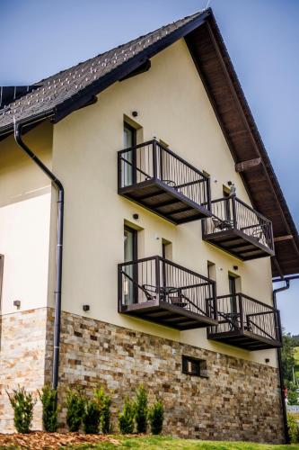 a building with balconies on the side of it at HP APARTMÁNY SKIAREÁL- Buková Hora v Orlických horách 100 m od lanovky in Červená Voda