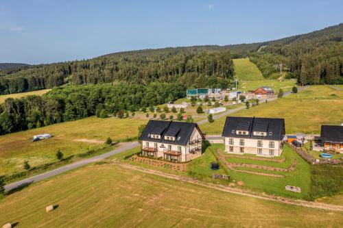 an aerial view of a large house on a hill at HP APARTMÁNY SKIAREÁL- Buková Hora v Orlických horách 100 m od lanovky in Červená Voda