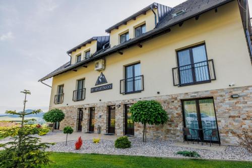 a building with black windows on the side of it at HP APARTMÁNY SKIAREÁL- Buková Hora v Orlických horách 100 m od lanovky in Červená Voda
