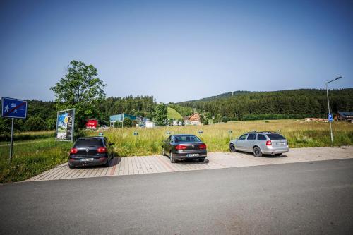 a group of three cars parked in a parking lot at HP APARTMÁNY SKIAREÁL- Buková Hora v Orlických horách 100 m od lanovky in Červená Voda