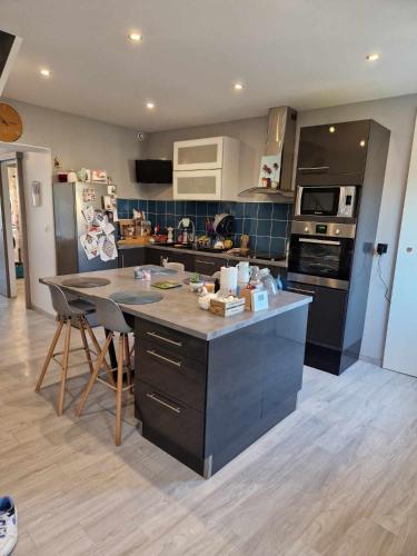 - une cuisine avec un îlot au milieu d'une pièce dans l'établissement Maison rade, à Cherbourg en Cotentin