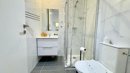 a bathroom with a shower and a toilet and a sink at Casa Amarela Guesthouse in Albufeira