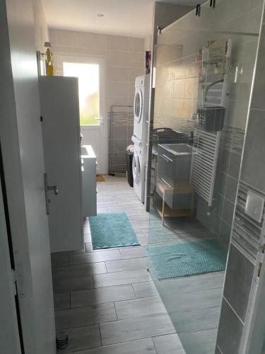 une salle de bain avec un lavabo et une machine à laver dans l'établissement Maison rade, à Cherbourg en Cotentin