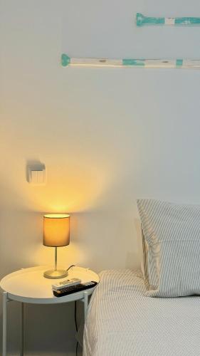 a bed with a table with a lamp next to a bed at Casa Amarela Guesthouse in Albufeira