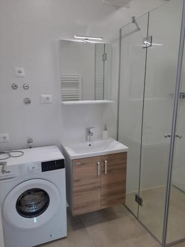 a bathroom with a washing machine and a sink at Smokvica - NEW in Primošten