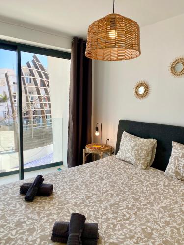 a bedroom with a bed with two pairs of shoes on it at Mulata Doré Suite in Corralejo