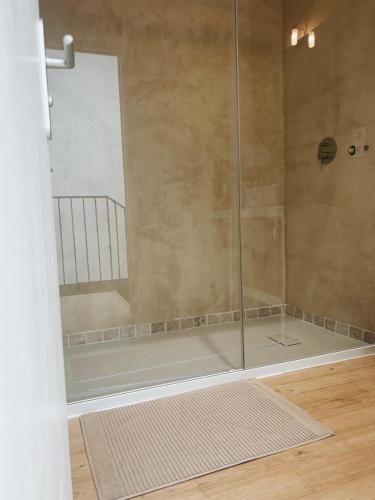 une douche avec une porte vitrée dans une salle de bain dans l'établissement La Paca Majuca, à Saint-Thibéry