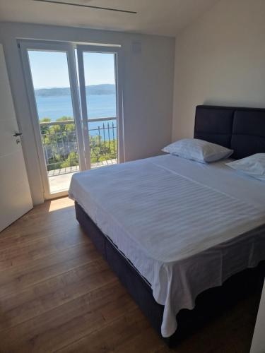 a bedroom with a bed with a view of the ocean at Apartman SIX in Brela