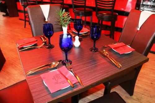 a wooden table with wine glasses and utensils on it at EDC UUM Sintok in Sintuk