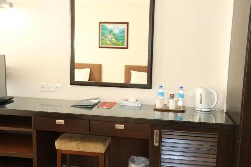 a desk in a hotel room with a mirror at EDC UUM Sintok in Sintuk