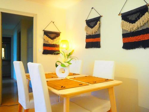 - une table à manger avec des chaises blanches et une table en bois dans l'établissement Charmant Appartement au Pecq - Proche de Saint-Germain-en-Laye, à Le Pecq