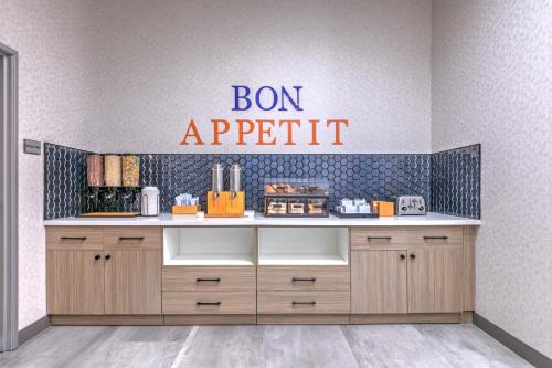 a kitchen with a counter with a sign that reads bon appetite at Hampton Inn & Suites by Hilton Shenandoah The Woodlands in The Woodlands