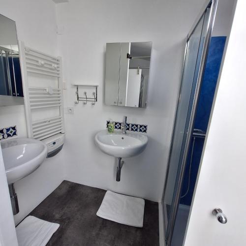 une salle de bain blanche avec deux lavabos et une douche dans l'établissement Location au cœur de la Provence, à Lamanon