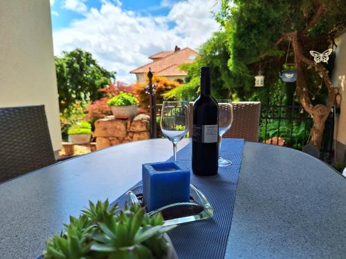 a bottle of wine sitting on a table with a glass at Appartements Regina in Mörbisch am See