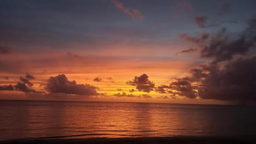 a sunset on the beach with the ocean at Boquerón Beach & Country Cabins in Boqueron