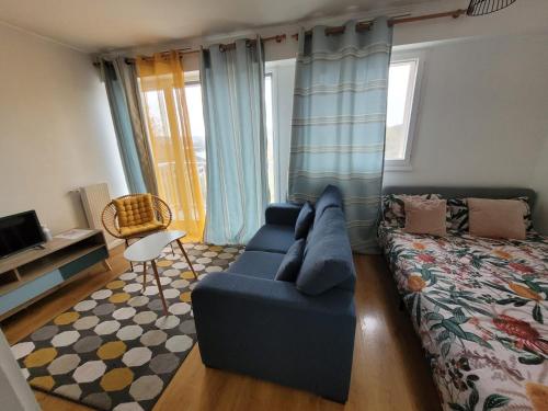 un salon avec un canapé et un lit dans l'établissement Charmant Studio avec Vue sur l'Orge, Proche RER et Aéroport d'Orly, à Savigny-sur-Orge