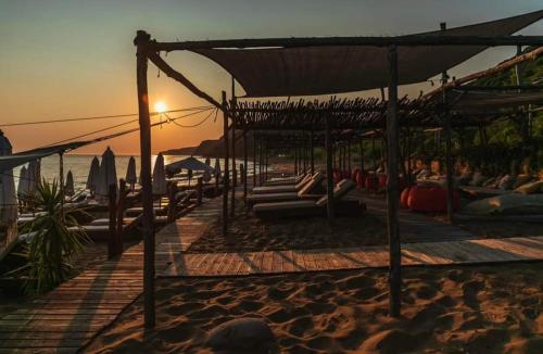 a group of people laying on the beach at sunset at Josephine's House in Neochórion