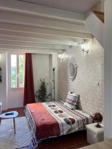 une chambre avec un lit et un mur de briques dans l'établissement MAGNIFIQUE DUPLEXE calme et climatisé, à 2 pas d'intra muros, à Avignon