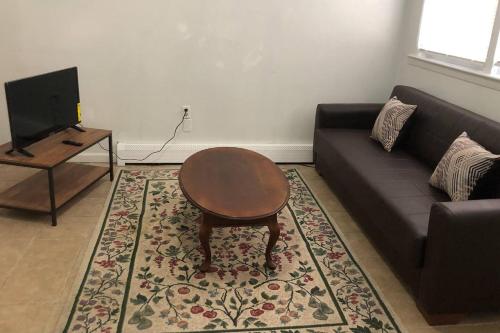 a living room with a couch and a table at Private 3 bedroom and 1 bathroom house, direct NYC Manhattan train a 15 minute walk away, MetLife Stadium FIFA World Cup 35 minutes away in Perth Amboy