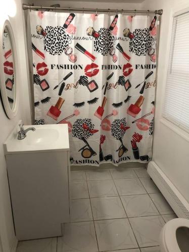 a bathroom with a shower curtain and a sink at Private 3 bedroom and 1 bathroom house, direct NYC Manhattan train a 15 minute walk away, MetLife Stadium FIFA World Cup 35 minutes away in Perth Amboy