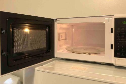 a microwave oven with a plate inside of it at Spacious and bright 2 bedroom apartment with 1 bathroom and private street entrance in Paterson