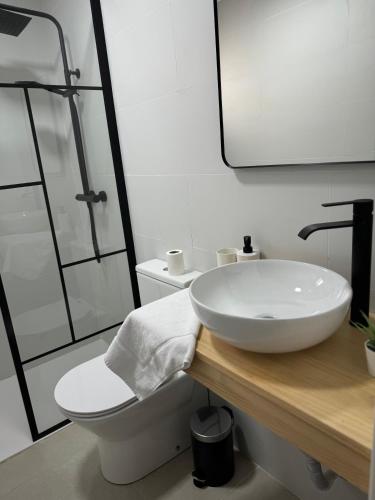 a white bathroom with a sink and a toilet at Alojamiento Baeza California 2A in Baeza