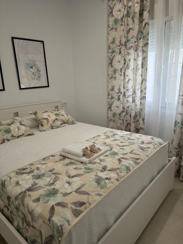 a bedroom with a bed with a floral bedspread at Alojamiento Baeza California 2A in Baeza