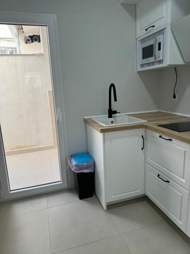 a small kitchen with a sink and a microwave at Alojamiento Baeza California 2A in Baeza