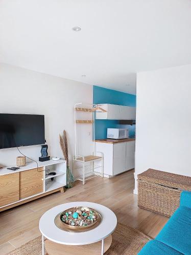 un salon avec un canapé et une table dans l'établissement L'oasis d'Anatole, à Oyonnax