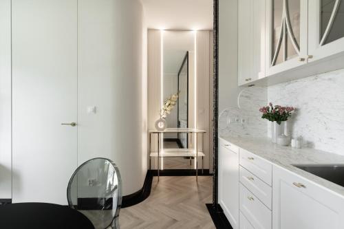 a kitchen with white cabinets and a mirror at M&K Apartament Perła Sobieszewo - Wyspa Sobieszewska in Jazowa