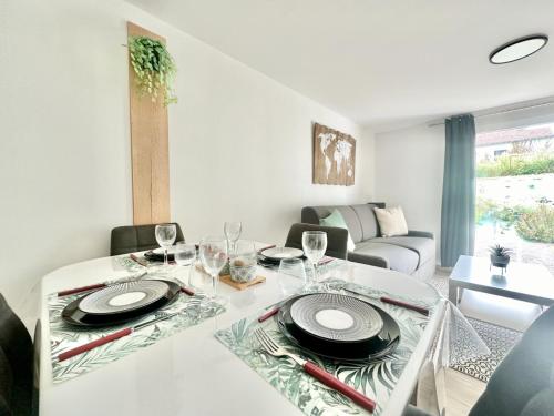 une salle à manger avec une table avec des assiettes et des verres à vin dans l'établissement Le Kaolin, cosy et calme, à Limoges