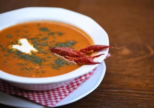 a bowl of soup on a table with a piece of food at Malinowe Wzgórze domki 90 m2 z sauną i balią in Krzeszna