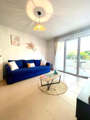 un salon avec un canapé bleu et une table dans l'établissement Parfum de Provence, terrasse, centre-ville, parking privé, à Draguignan